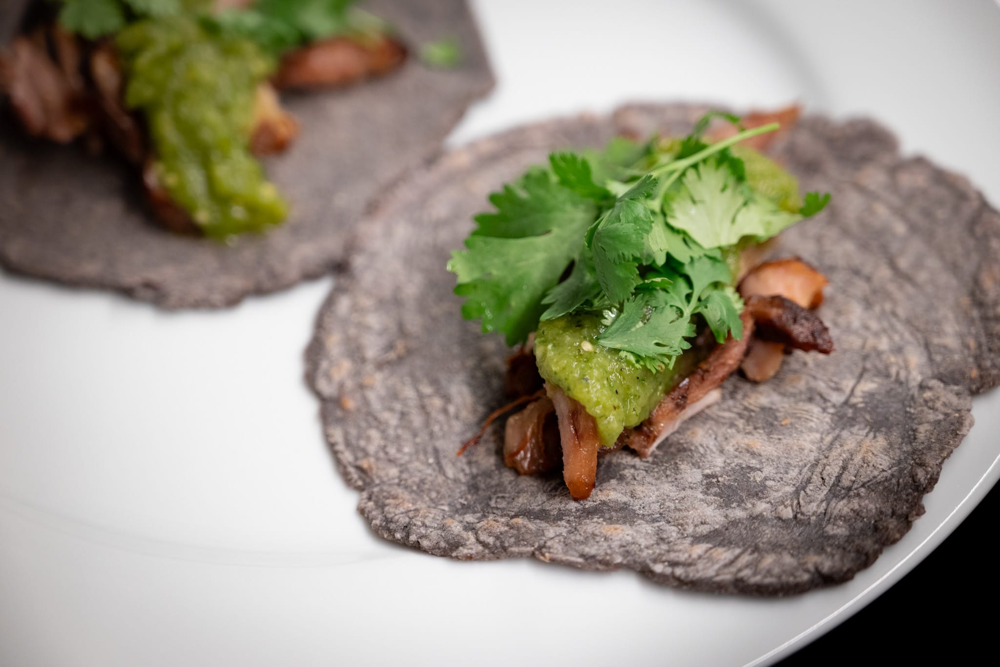 Carnitas with salsa verde on blue corn tortillas