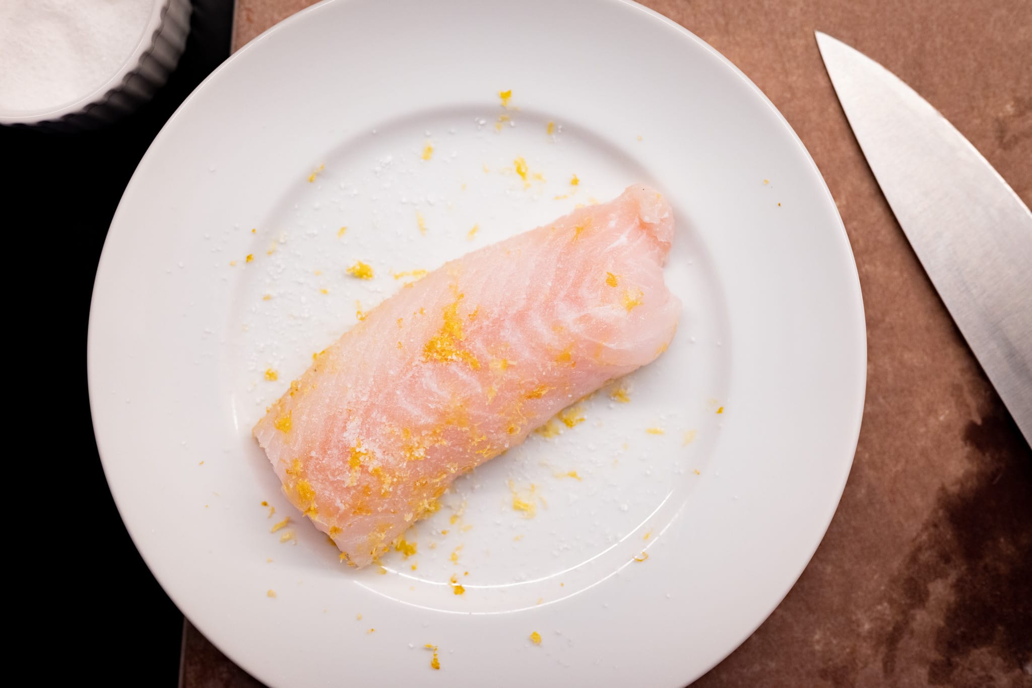 Lemon zest and salt on cod