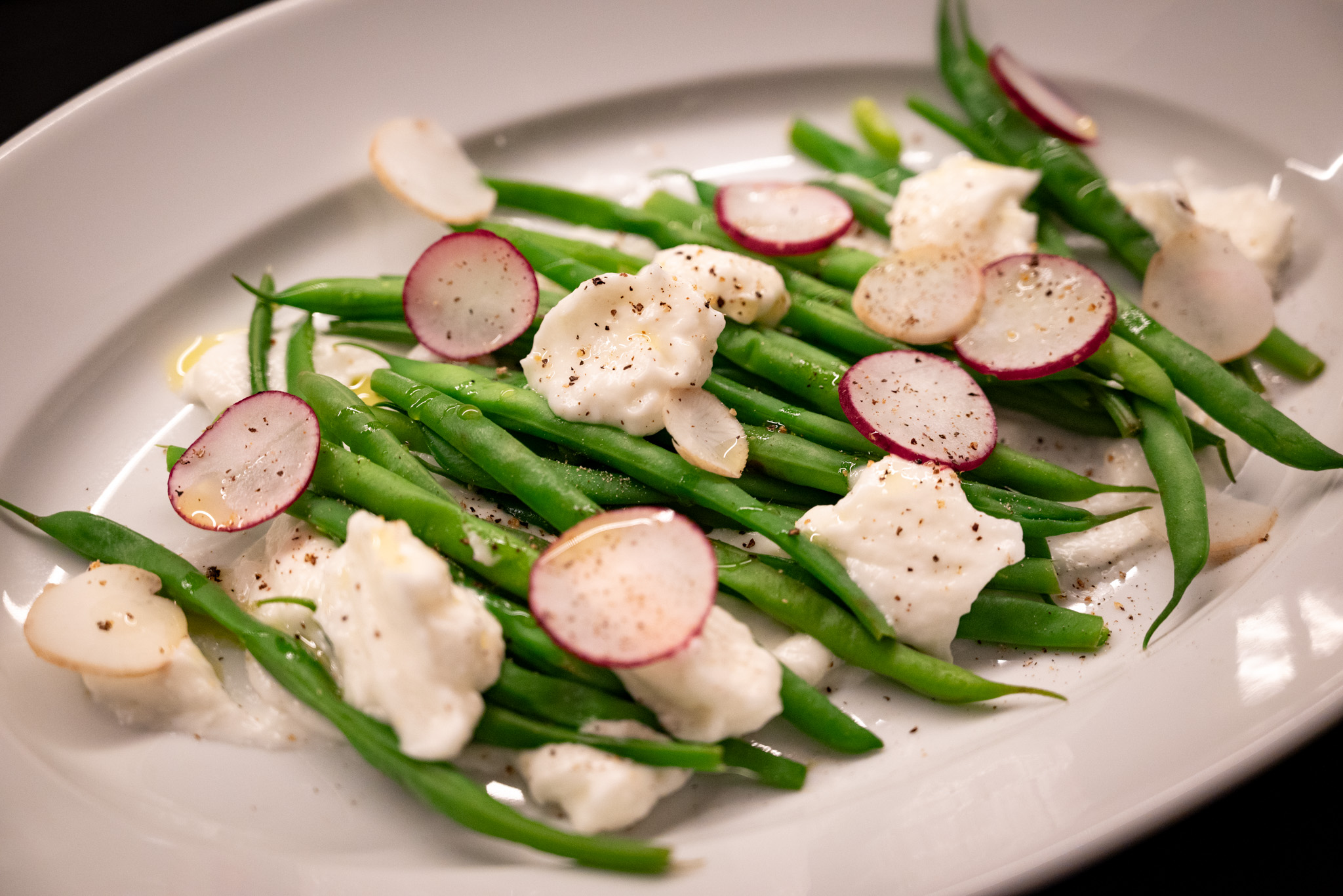 A dish of hericots verts with toum and radishes