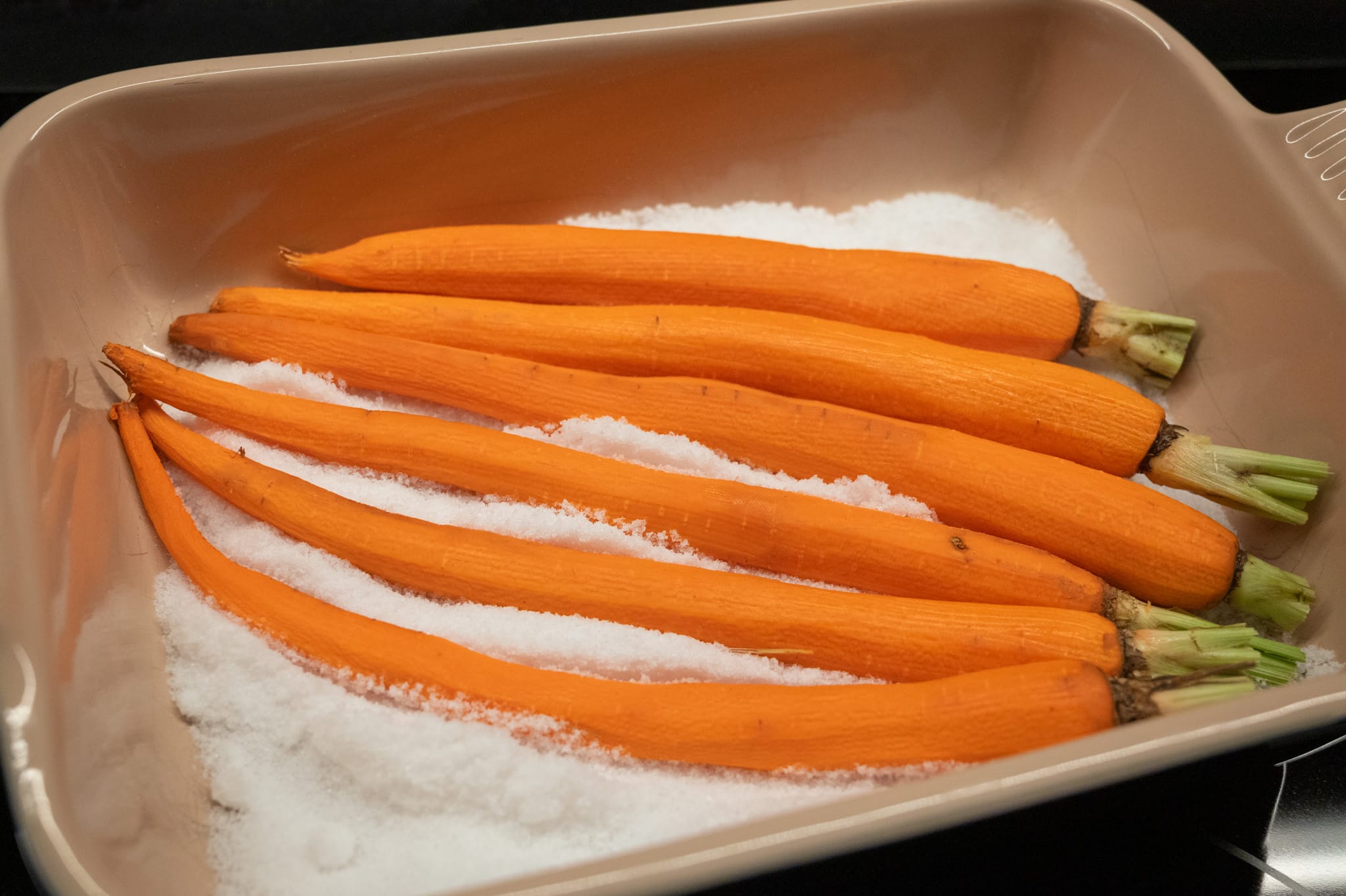 Peeled carrots in a bed of salt